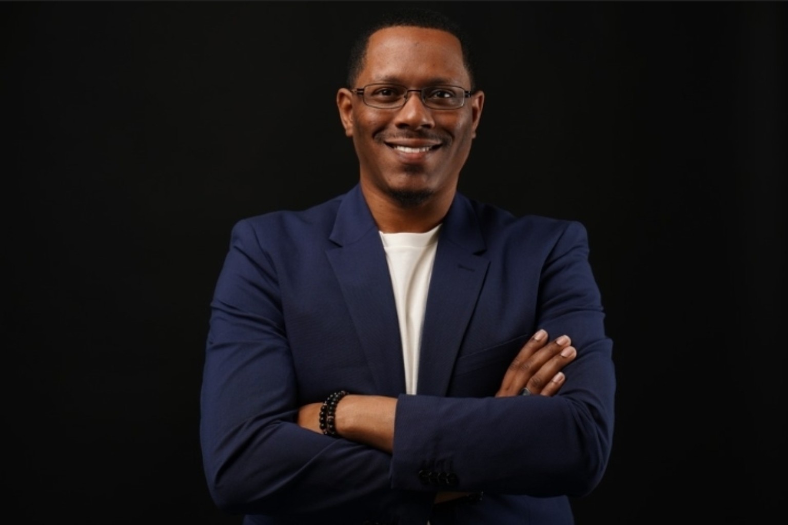 Jeremy Fusilier Sr. in a blazer with arms folded